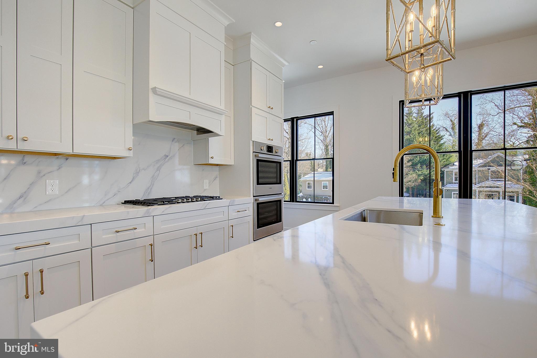 13 Elliott Road Annapolis, MD 21403 - Photo 10 of 14 a large white kitchen with stainless steel appliances granite countertop a stove a sink dishwasher and white cabinets with wooden floor