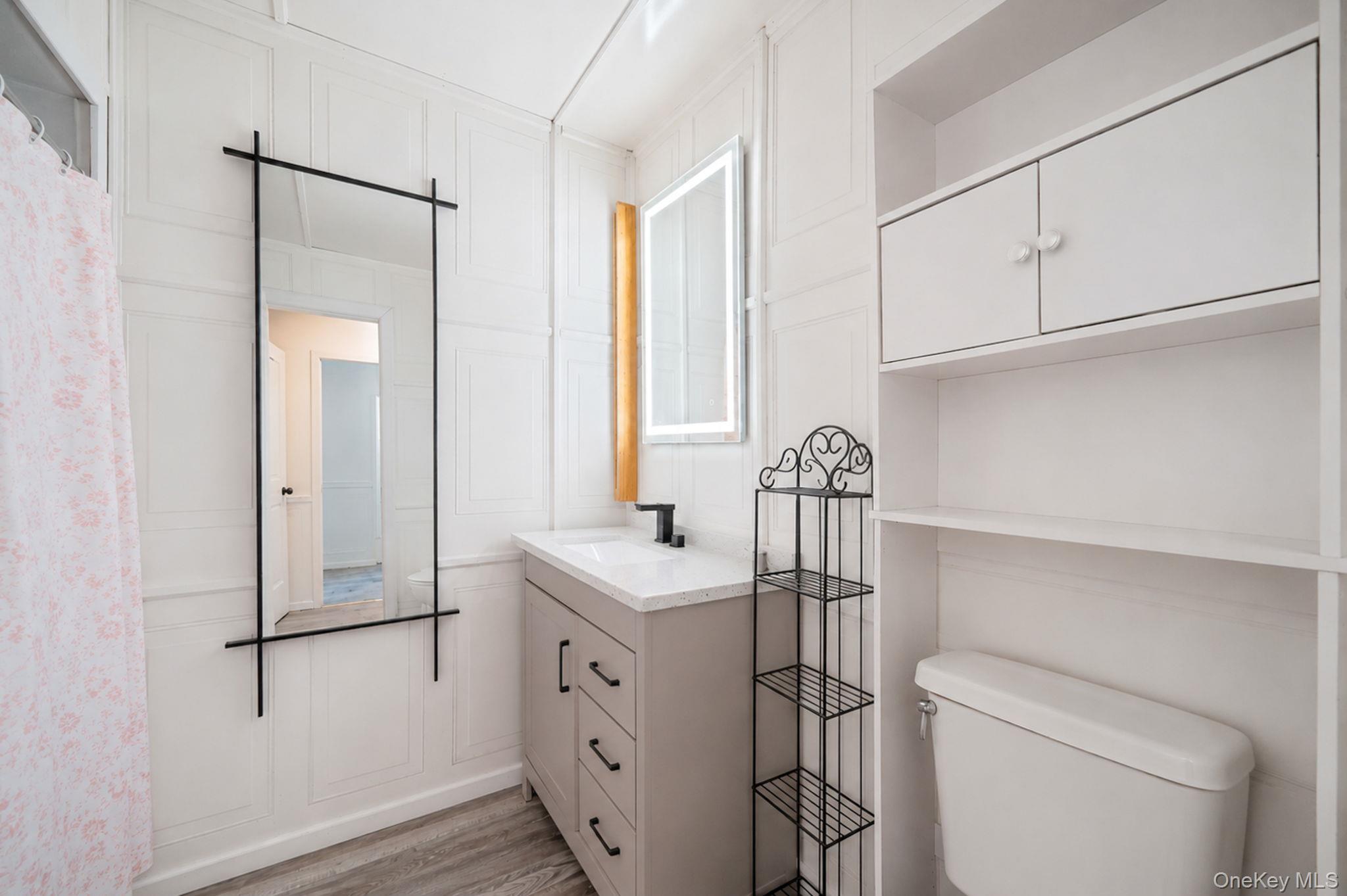 85 Applegate Drive Central Islip, NY 11722 - Photo 19 of 33 a bathroom with a sink a toilet and a mirror