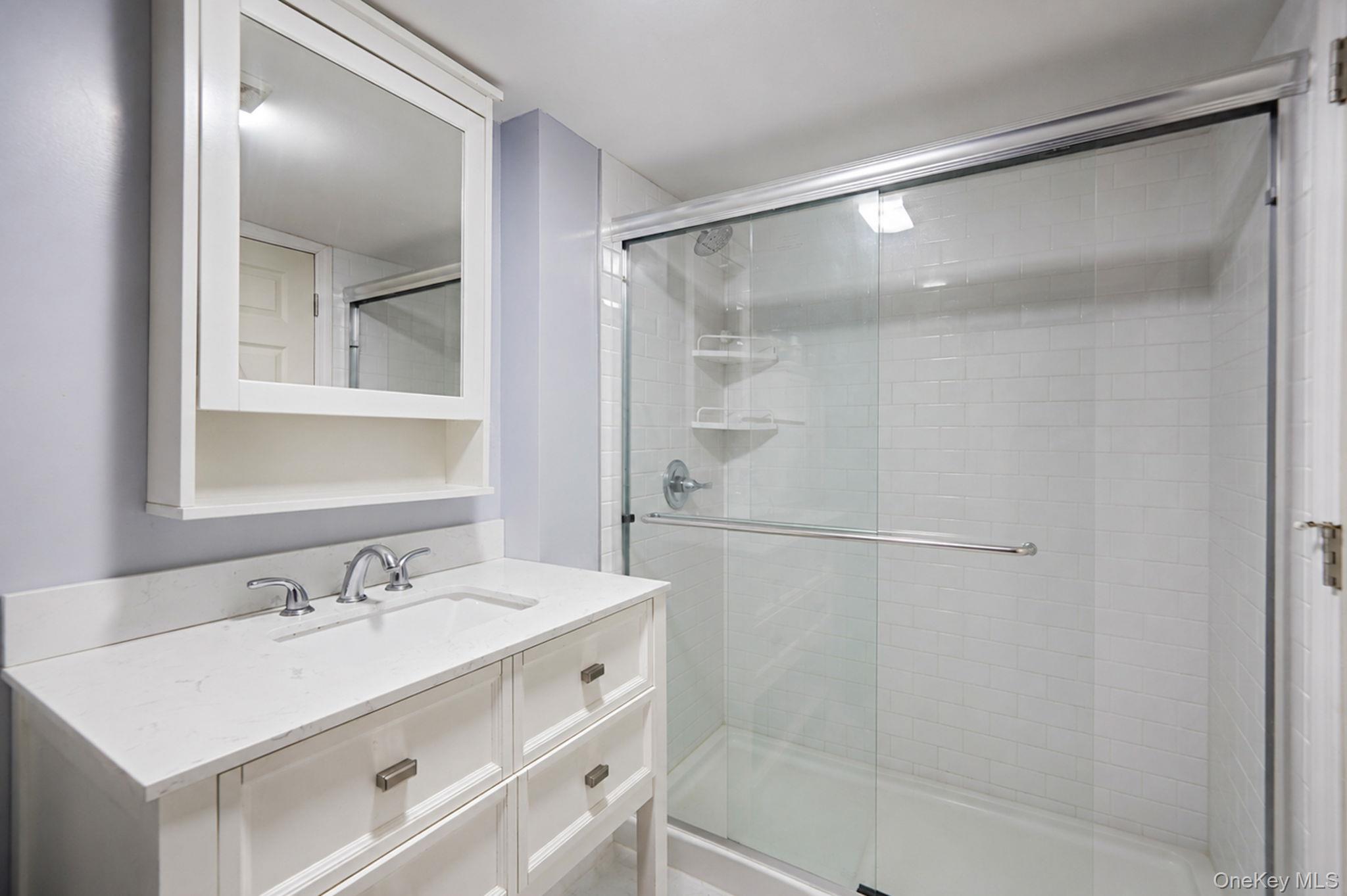 85 Applegate Drive Central Islip, NY 11722 - Photo 27 of 33 a bathroom with a shower sink vanity and mirror
