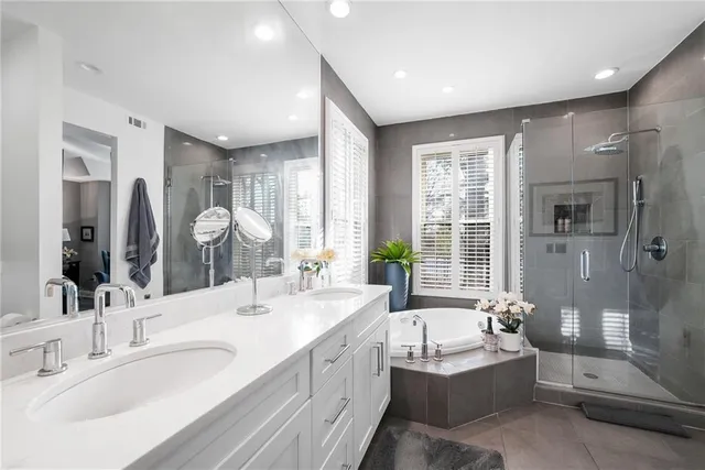 a bathroom with a granite countertop tub sink and mirror