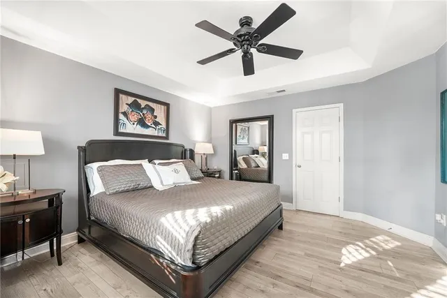 a bedroom with a bed chandelier painting on the wall and a window