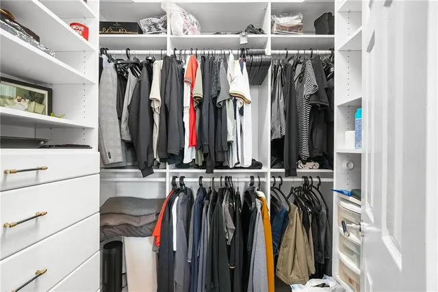 a view of walk in closet with clothes