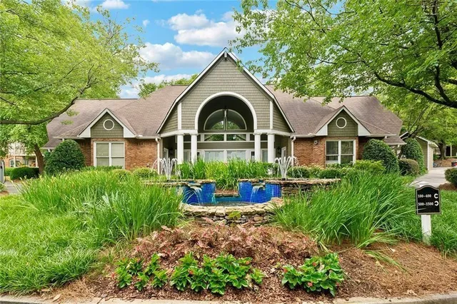 a front view of a house with yard and green space