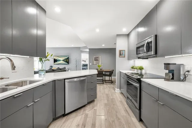 a kitchen with stainless steel appliances granite countertop sink stove top oven and cabinets