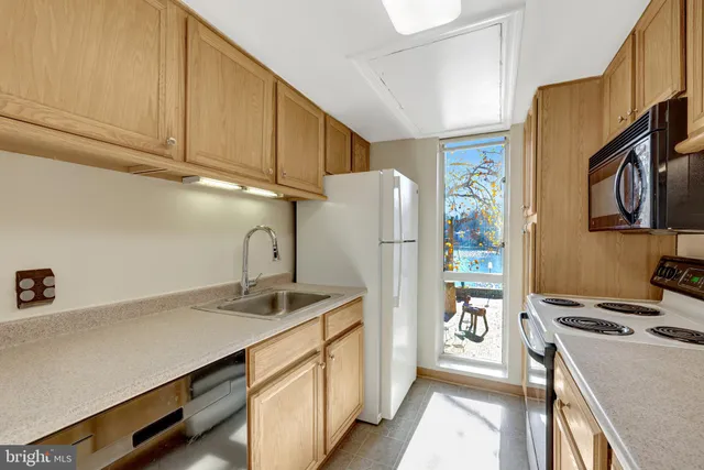 a kitchen with stainless steel appliances a stove a refrigerator a sink and cabinets
