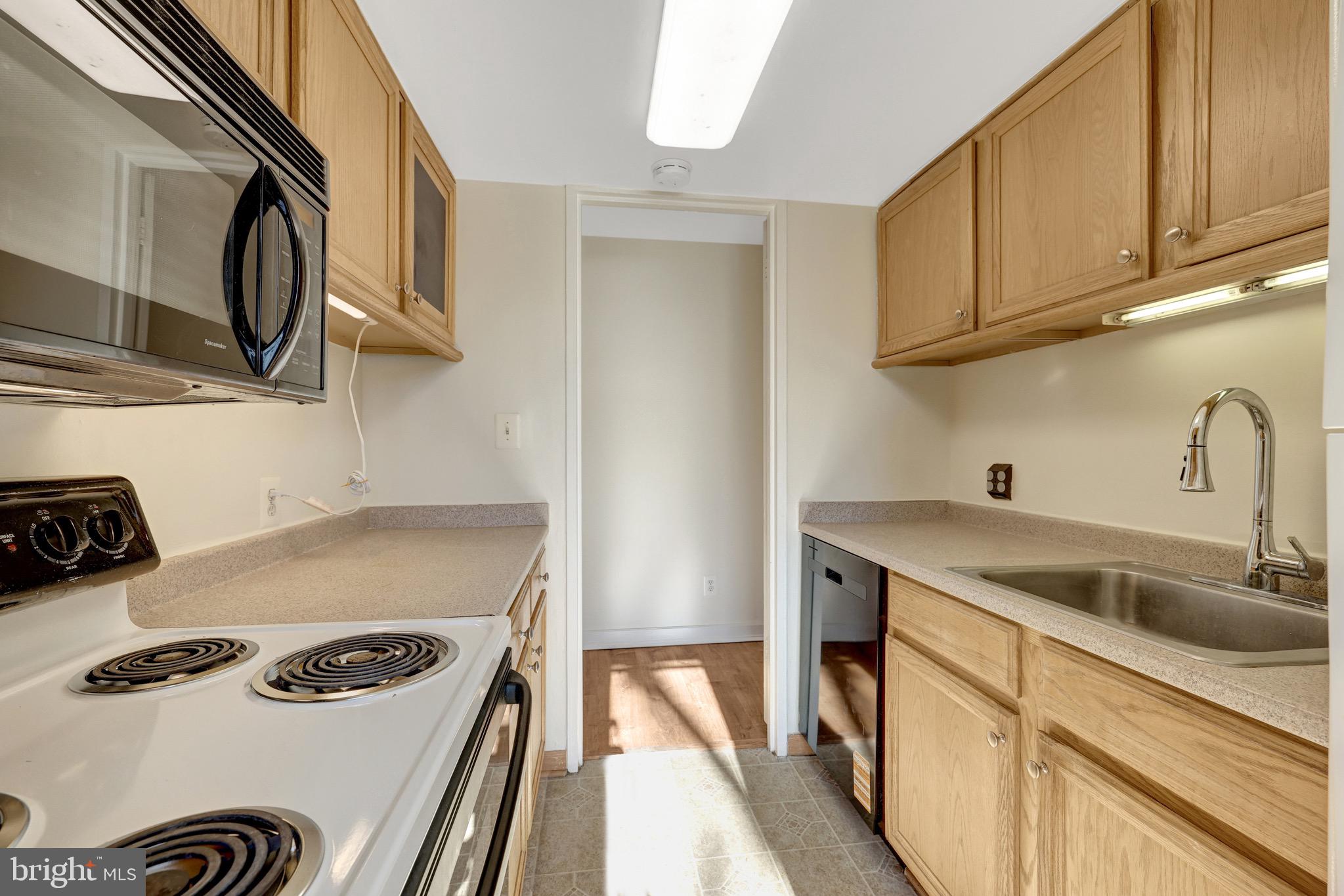 11400 Washington Plaza West, Unit 103 Reston, VA 20190 - Photo 22 of 57 a kitchen with stainless steel appliances granite countertop a sink stove and refrigerator