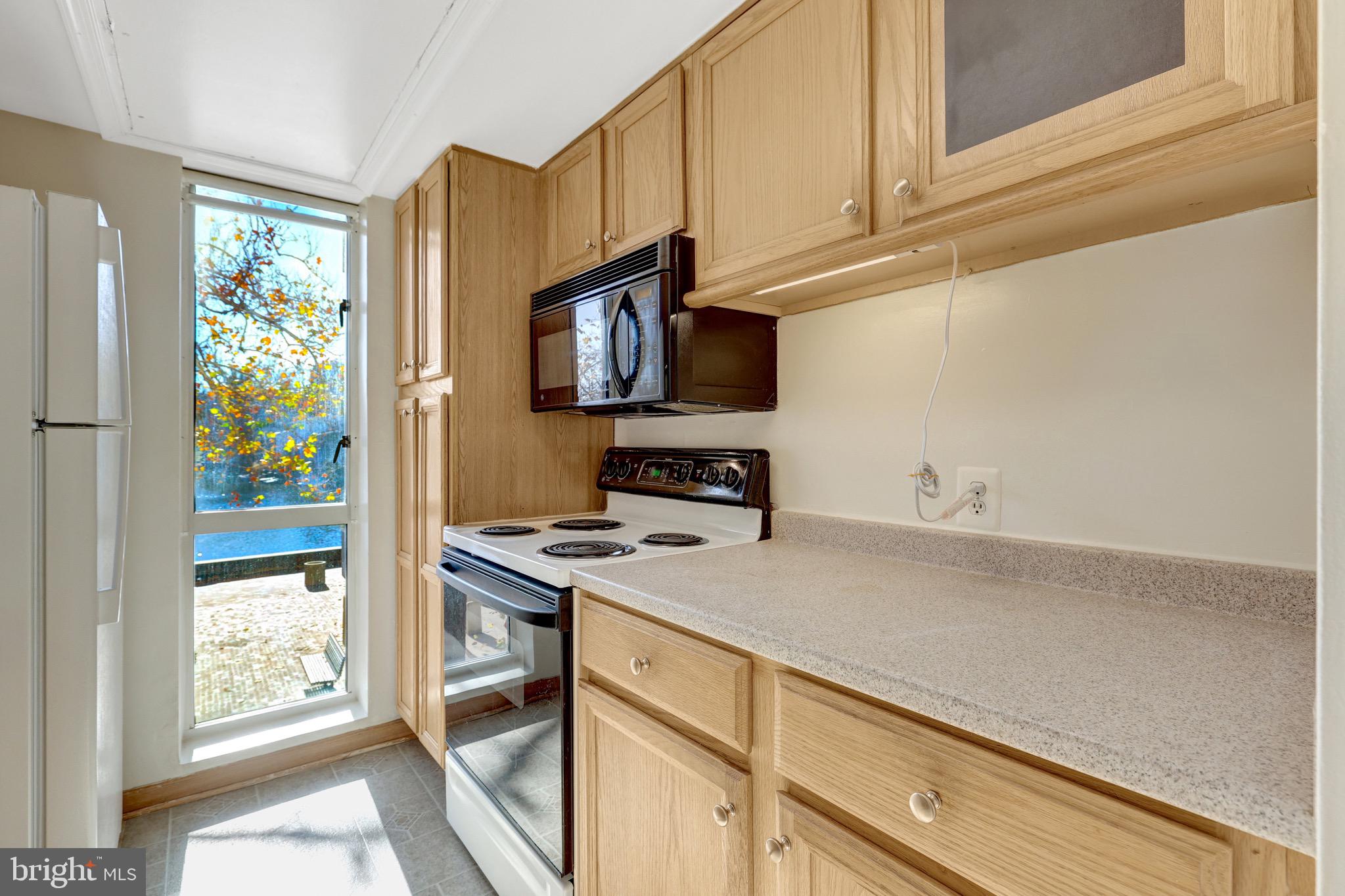11400 Washington Plaza West, Unit 103 Reston, VA 20190 - Photo 23 of 57 a kitchen with stainless steel appliances a stove a refrigerator a sink and cabinets