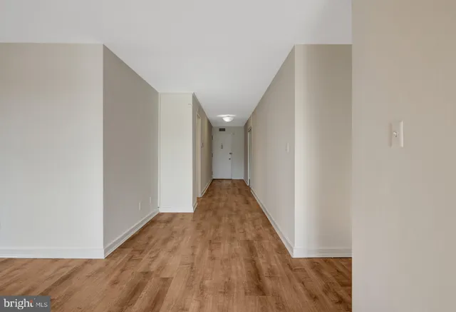 a view of empty room with wooden floor