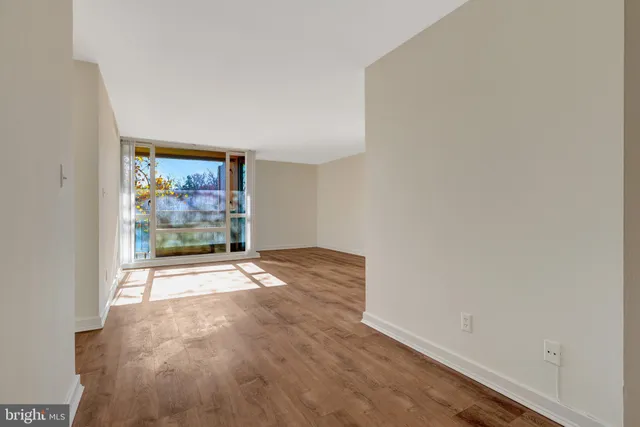 a view of a livingroom with wooden floor and a balcony