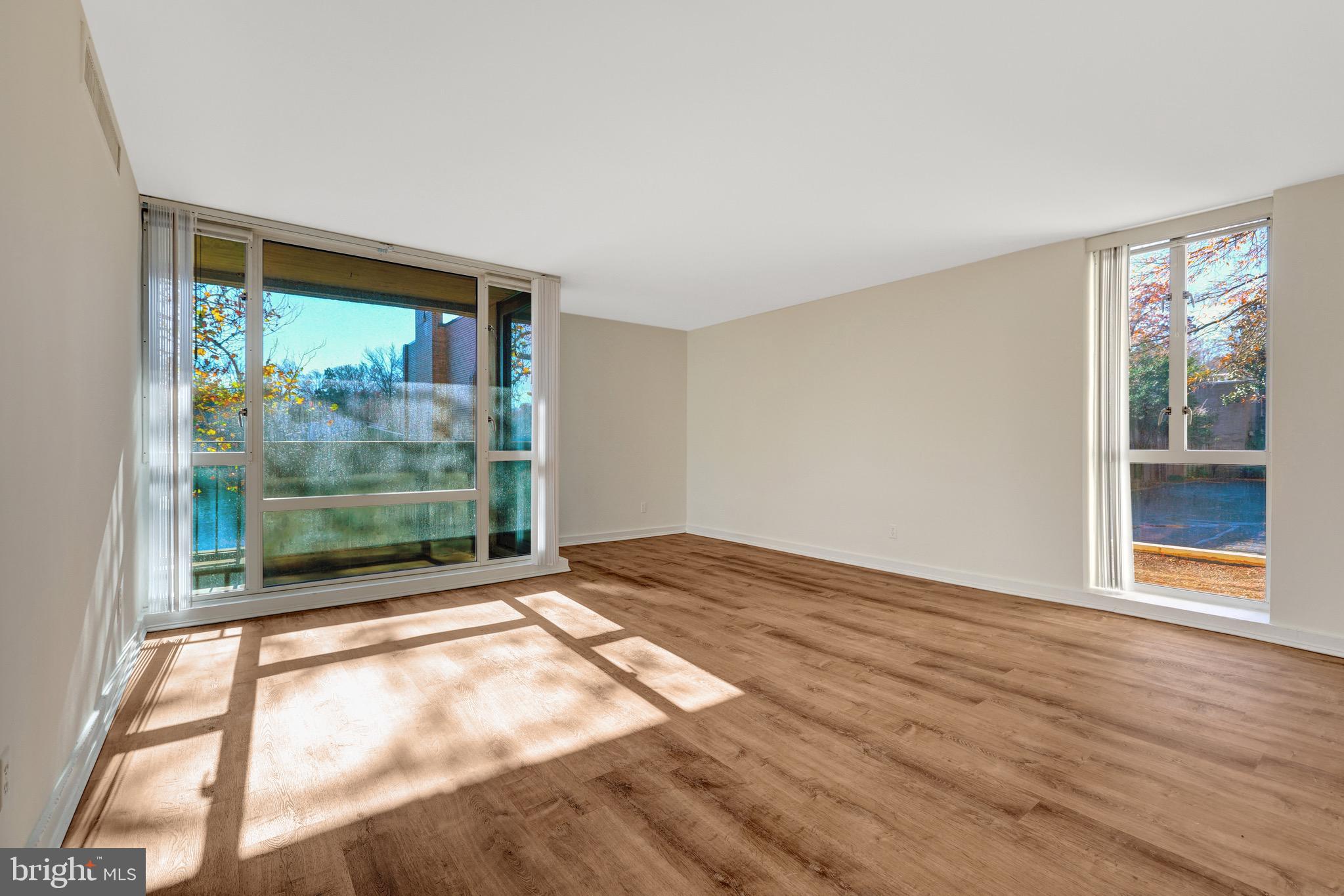 11400 Washington Plaza West, Unit 103 Reston, VA 20190 - Photo 28 of 57 a view of an empty room with wooden floor and a window