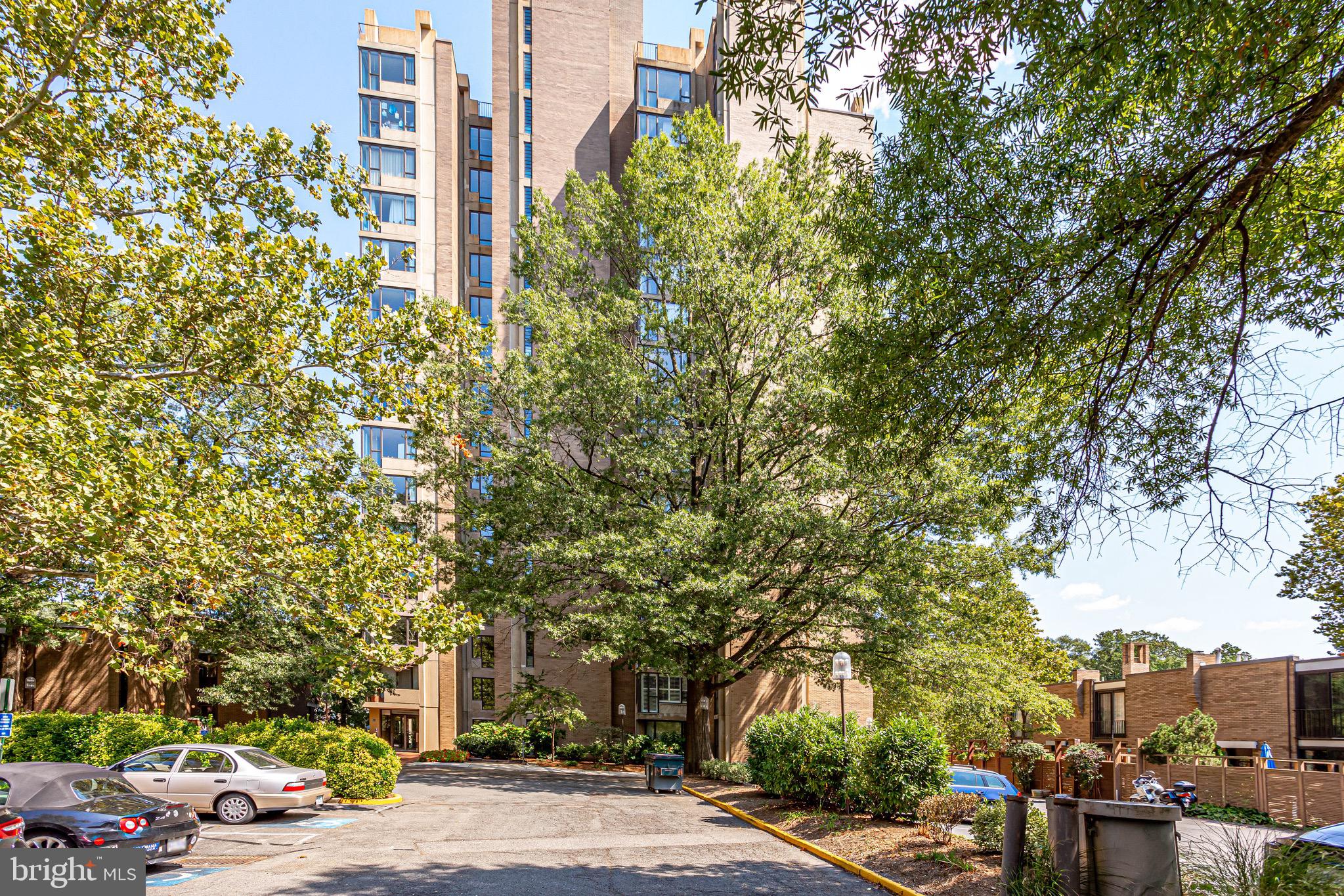 11400 Washington Plaza West, Unit 103 Reston, VA 20190 - Photo 3 of 57 a tall building with trees in front of it