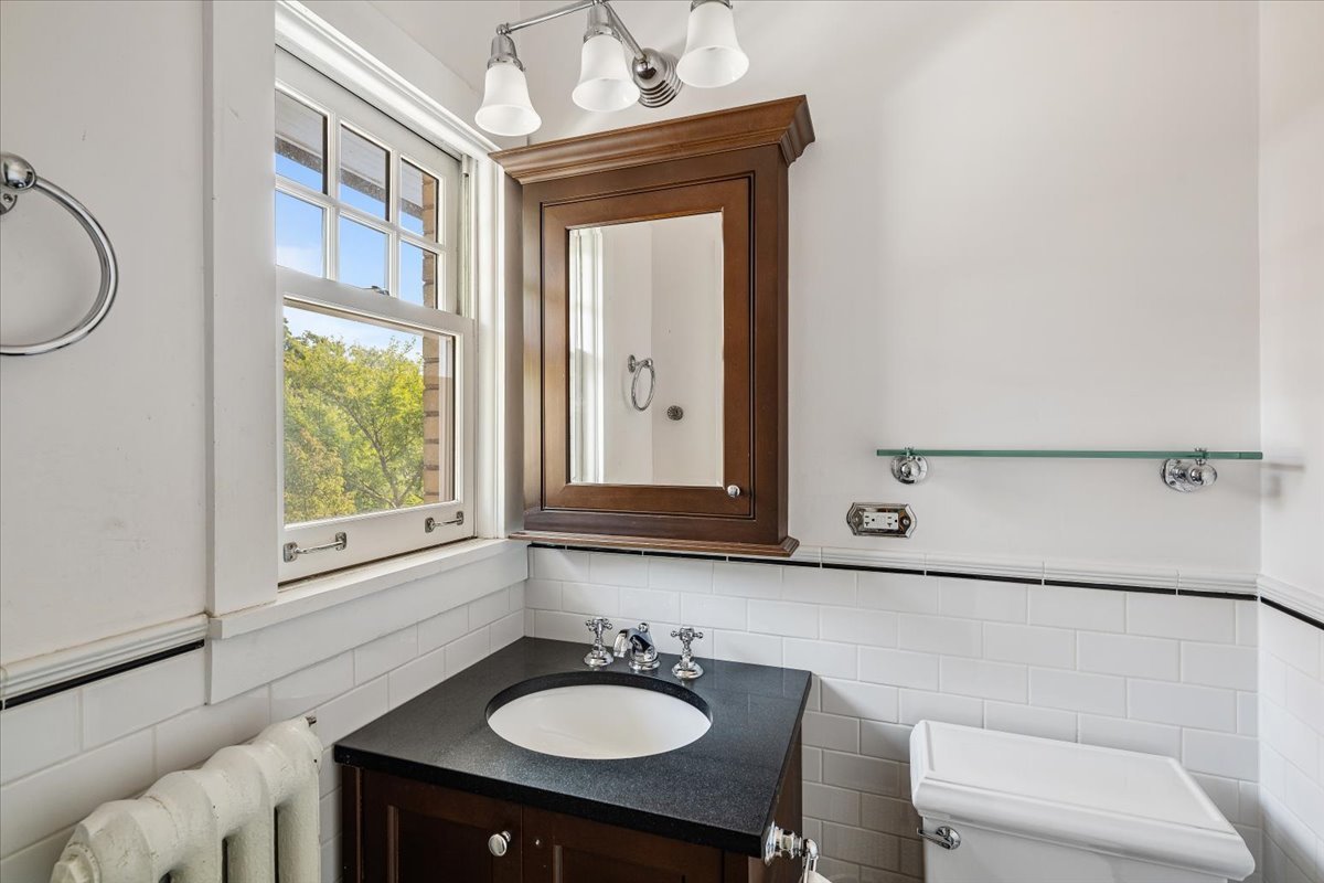 411 Sheridan Road Wilmette, IL 60091 - Photo 28 of 43 a bathroom with a sink a mirror and a window