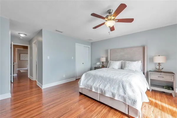 a bedroom with a large bed and a ceiling fan