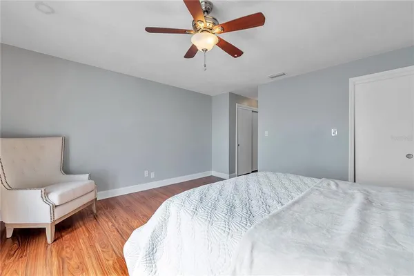 a bedroom with a bed and a wooden floor