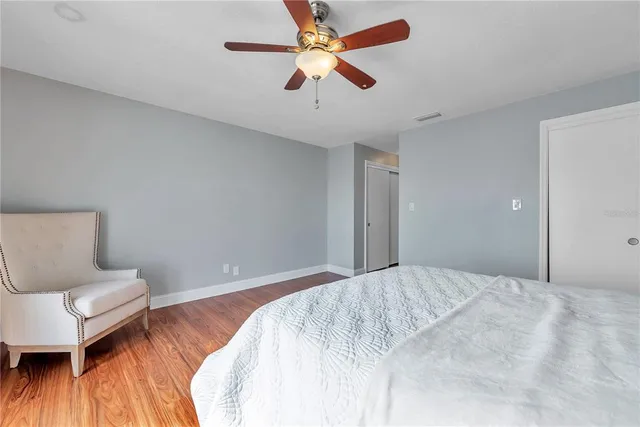 a bedroom with a bed and a wooden floor