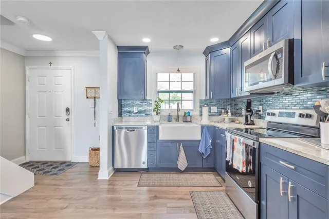 a kitchen with stainless steel appliances granite countertop a stove a sink and a refrigerator