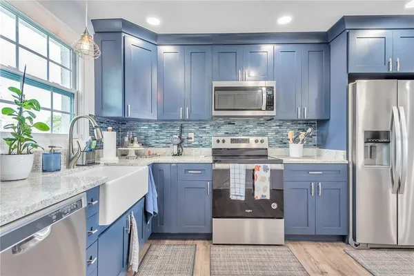 a kitchen with kitchen island granite countertop a sink stove and refrigerator
