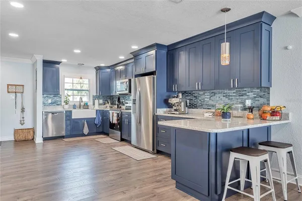 a kitchen with kitchen island stainless steel appliances cabinets a sink and a counter top space