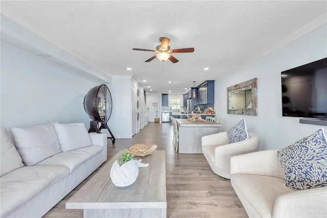 a living room with furniture a flat screen tv and a chandelier