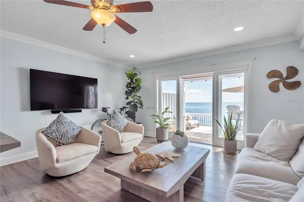 a living room with furniture a flat screen tv and a large window
