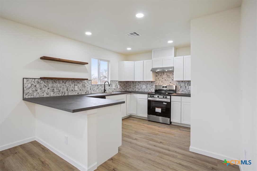 707 South 13th Street Temple, TX 76504 - Photo 11 of 24 a kitchen with granite countertop white cabinets and white appliances