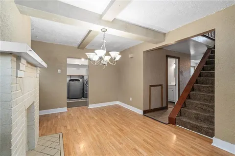 wooden floor in an empty room with a chandelier fan