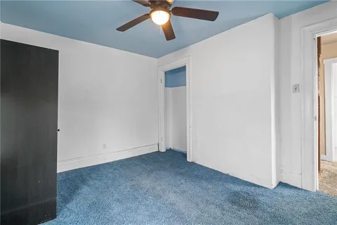 an empty room with chandelier fan
