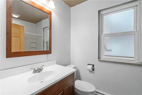 a bathroom with a sink vanity mirror and toilet