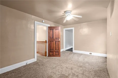 an empty room with chandelier fan