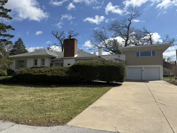 a front view of a house with yard and a garage