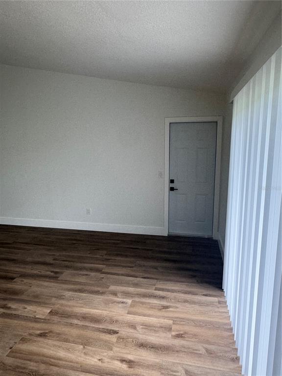 18208 State Road 52 Land O Lakes, FL 34638 - Photo 11 of 44 a view of room with wooden floor and white walls