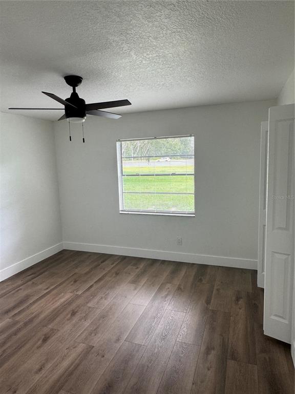 18208 State Road 52 Land O Lakes, FL 34638 - Photo 15 of 44 an empty room with wooden floor ceiling fan and windows