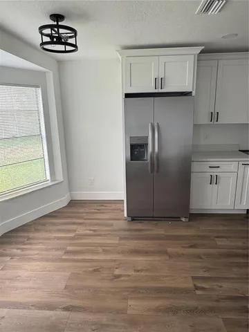 a kitchen with granite countertop a refrigerator and a sink