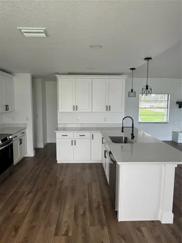 a kitchen with a sink cabinets and wooden floor
