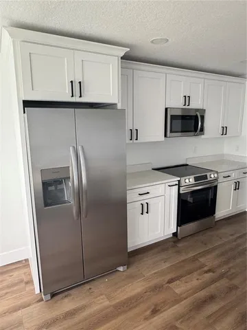a kitchen with white cabinets and stainless steel appliances