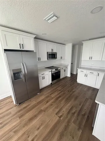 a kitchen with stainless steel appliances granite countertop a refrigerator a stove top oven a sink and dishwasher