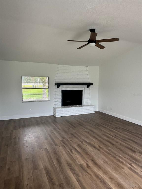 18208 State Road 52 Land O Lakes, FL 34638 - Photo 10 of 44 a view of empty room with wooden floor and fireplace