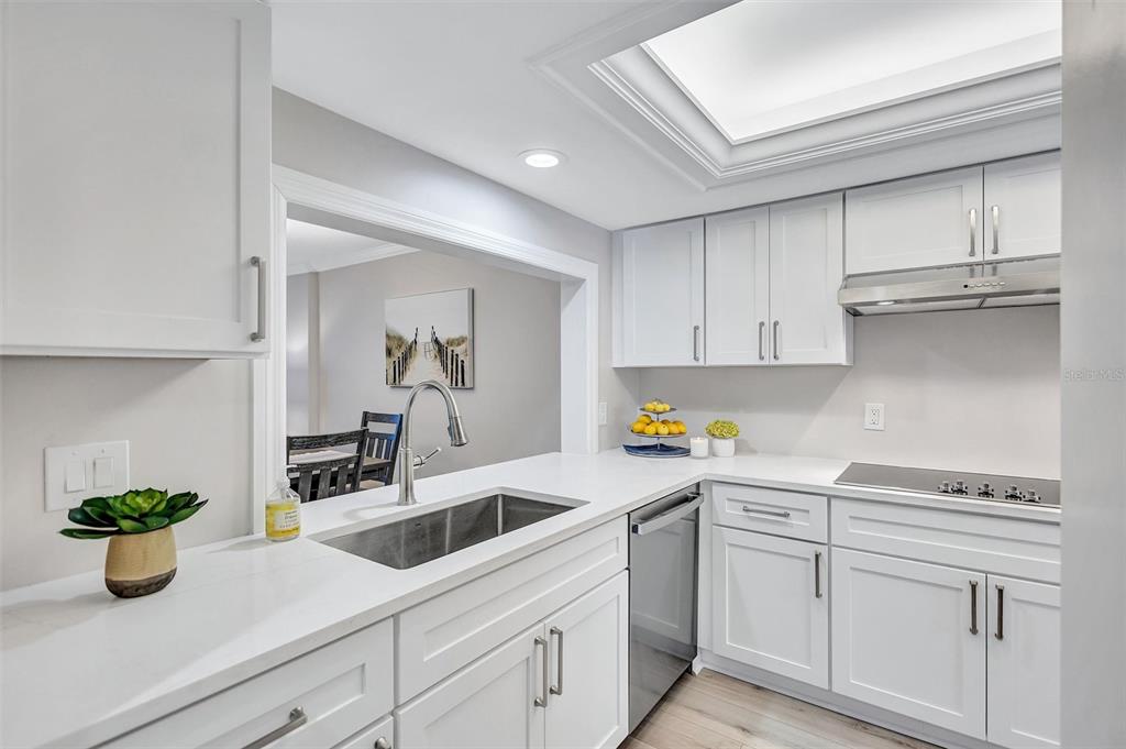 5880 Midnight Pass Road, Unit 306 Sarasota, FL 34242 - Photo 13 of 71 a kitchen with a sink and white cabinets