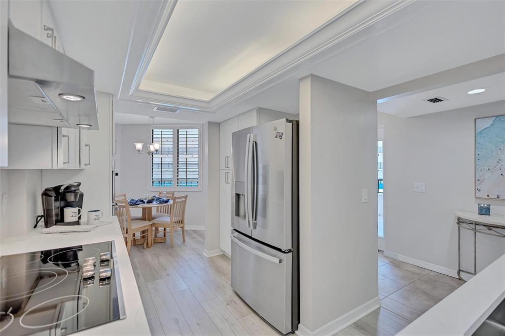 5880 Midnight Pass Road, Unit 306 Sarasota, FL 34242 - Photo 15 of 71 a kitchen with stainless steel appliances a refrigerator a dining table and chairs