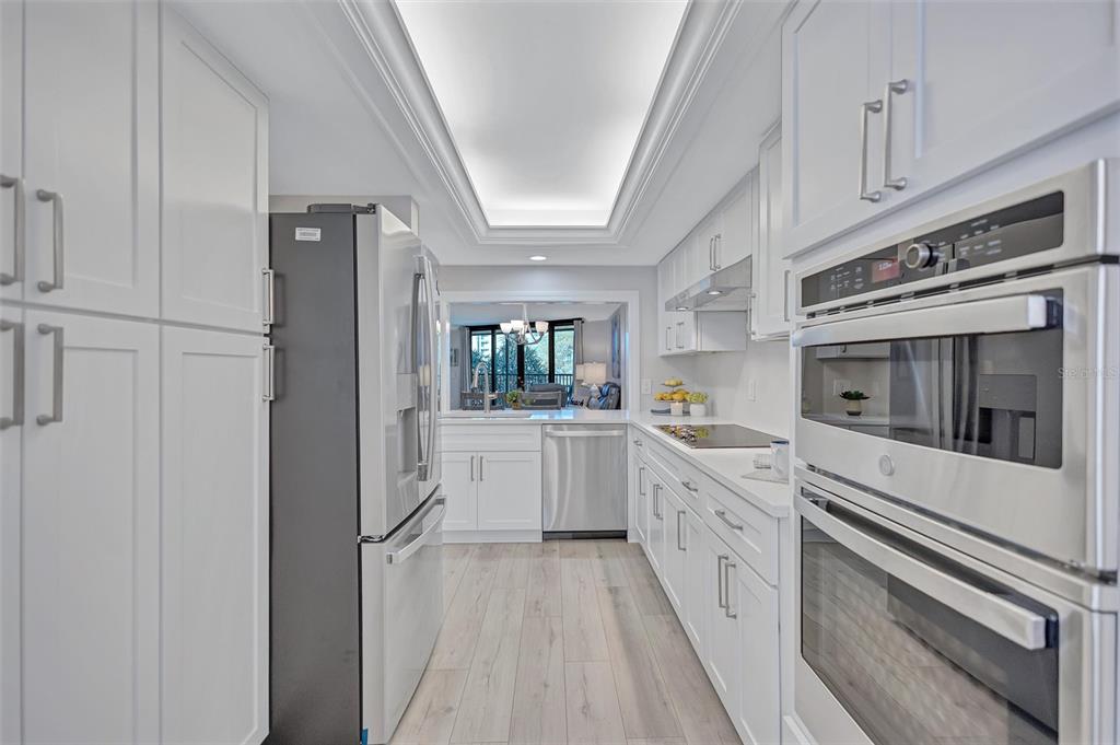 5880 Midnight Pass Road, Unit 306 Sarasota, FL 34242 - Photo 16 of 71 a kitchen with white cabinets and white appliances