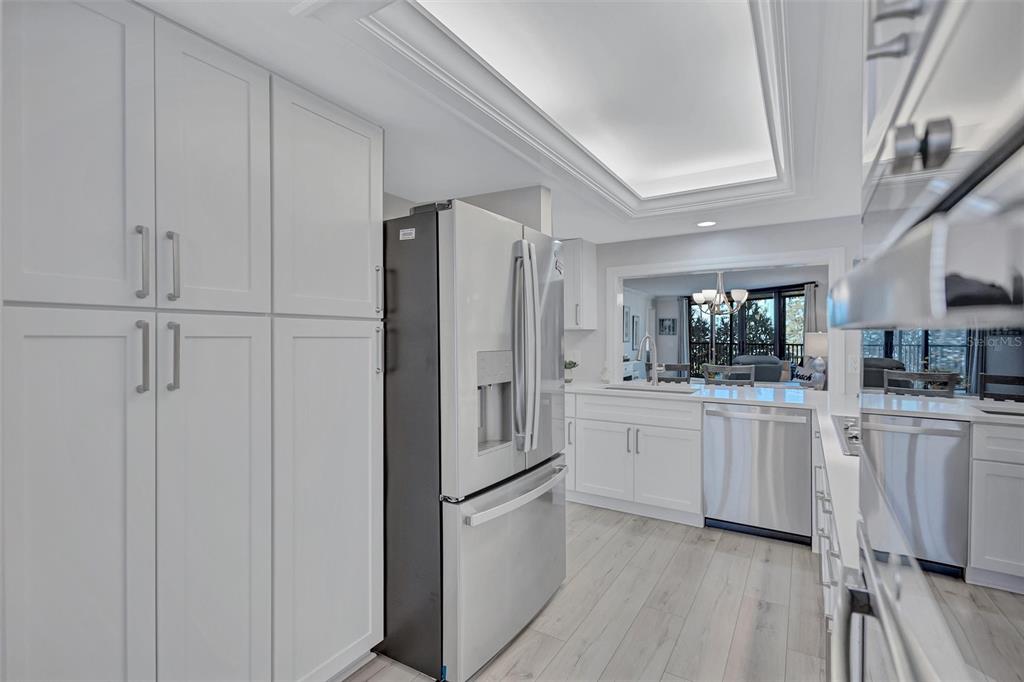 5880 Midnight Pass Road, Unit 306 Sarasota, FL 34242 - Photo 17 of 71 a kitchen with white cabinets and stainless steel appliances