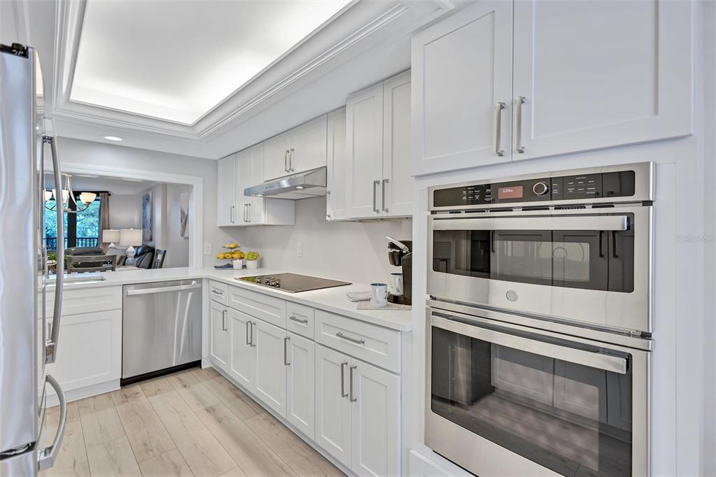 5880 Midnight Pass Road, Unit 306 Sarasota, FL 34242 - Photo 18 of 71 a kitchen with white cabinets and white appliances