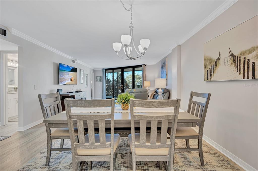 5880 Midnight Pass Road, Unit 306 Sarasota, FL 34242 - Photo 22 of 71 a view of a dining room with furniture wooden floor and chandelier