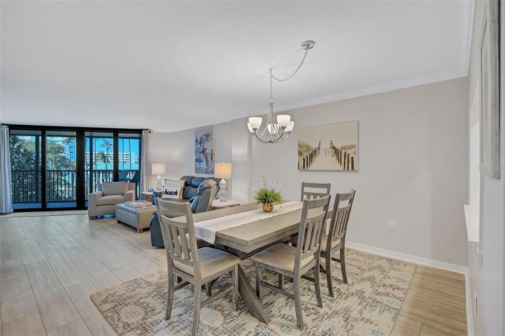 5880 Midnight Pass Road, Unit 306 Sarasota, FL 34242 - Photo 23 of 71 a view of a dining room with furniture wooden floor and chandelier