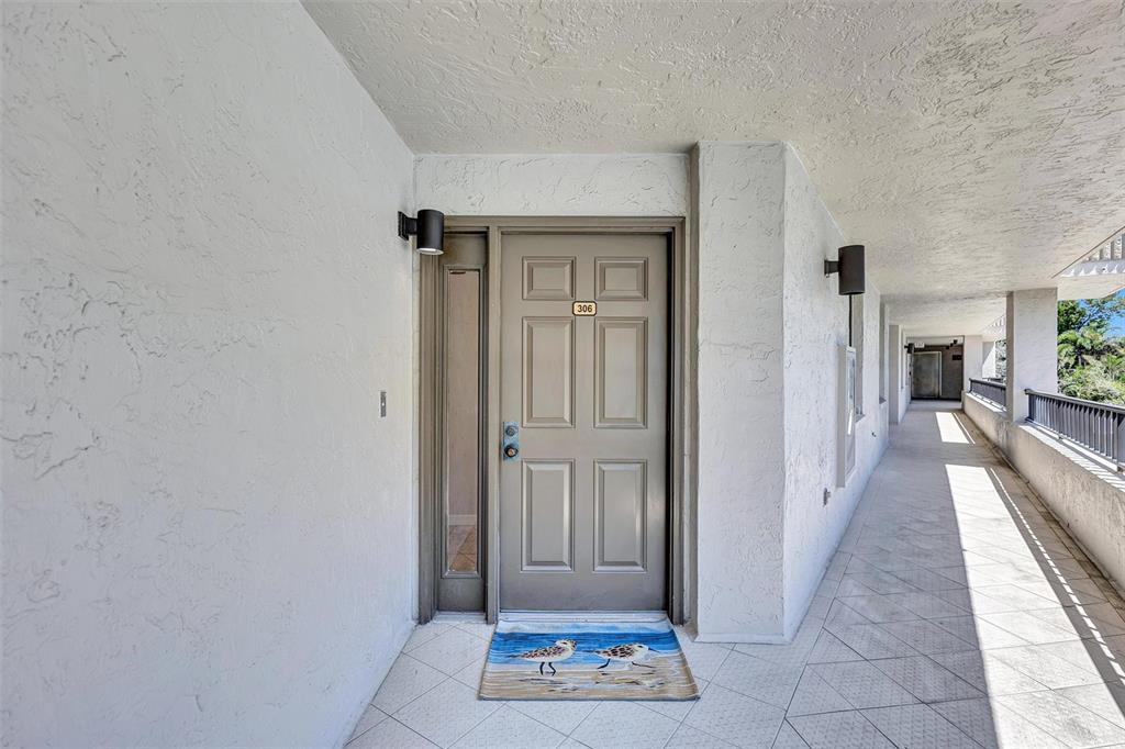 5880 Midnight Pass Road, Unit 306 Sarasota, FL 34242 - Photo 9 of 71 a view of a hallway with wooden floor and a living room