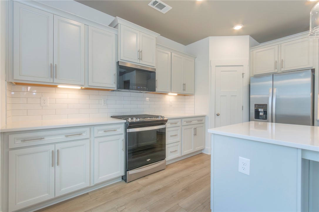 607 WH Kay Lane Anderson, SC 29621 - Photo 8 of 48 Culinary dreams come alive in this kitchen, featuring sleek stainless steel appliances and abundant cabinetry.