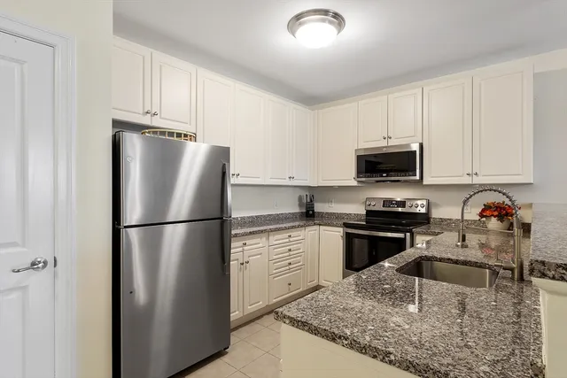 a kitchen with kitchen island a white cabinets and refrigerator