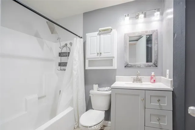 a bathroom with a sink toilet vanity and shower
