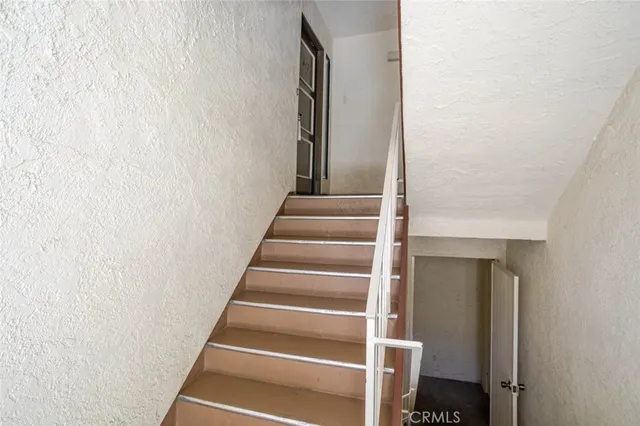 a view of staircase with white walls and railing