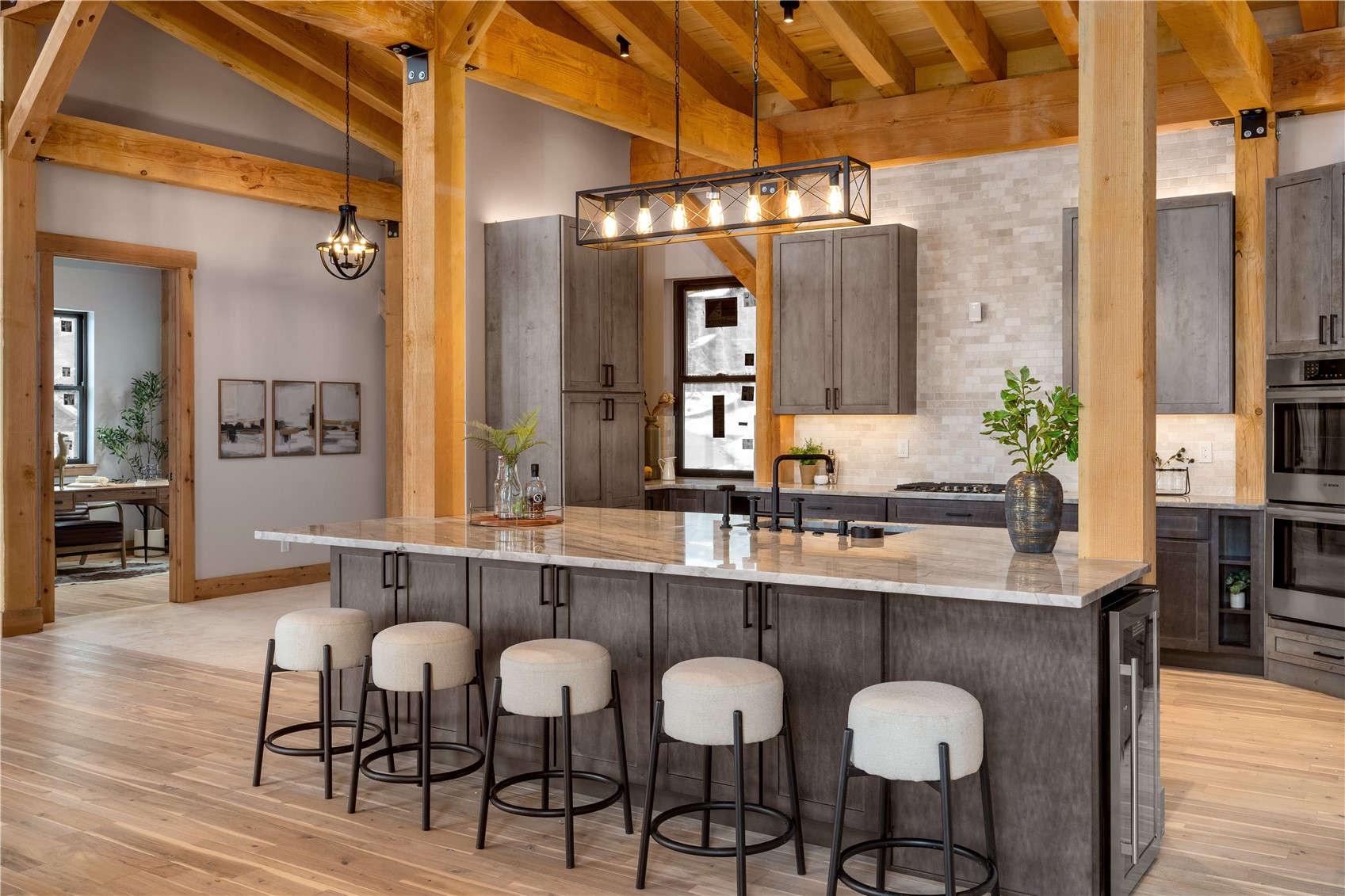 200 Sundance Court, Unit 1 Steamboat Springs, CO 80487 - Photo 4 of 50 Kitchen with hanging light fixtures, light stone countertops, double oven, a large island, and beverage cooler